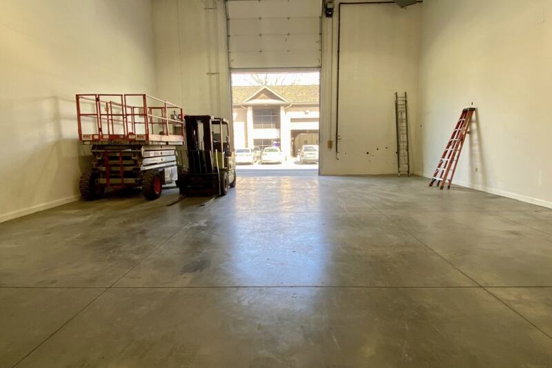 Interior of the ground floor warehouse at 1000 Cannons Court, Suite 103, looking toward the drive-in bay door.